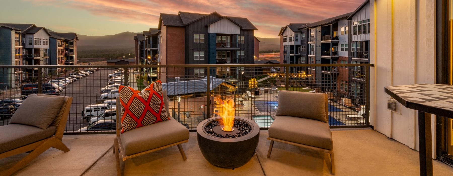 a patio with a fire pit and chairs and a fire pit