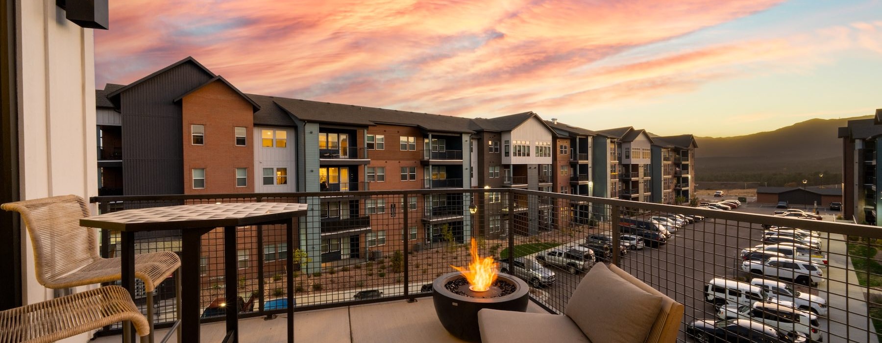 a patio with a fire pit and chairs and a fire pit